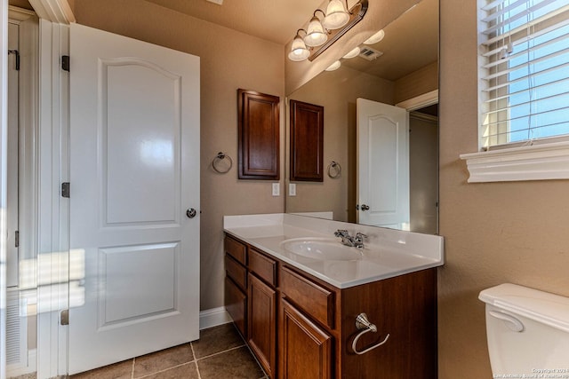 bathroom with tile patterned flooring, vanity, and toilet