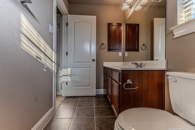 bathroom with tile patterned flooring, vanity, and toilet