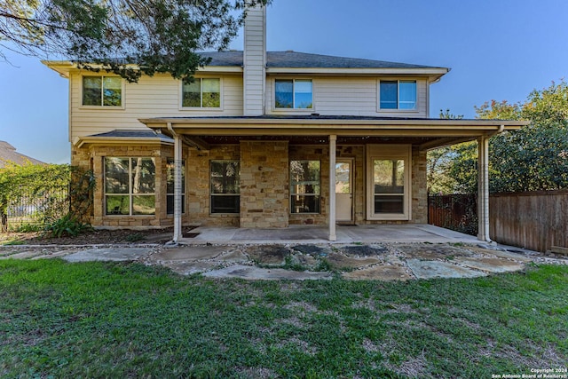 rear view of property with a lawn and a patio area