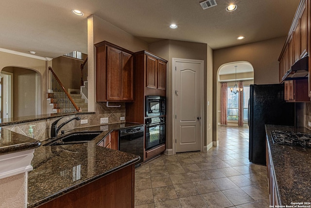 kitchen with black appliances, sink, dark stone counters, and tasteful backsplash