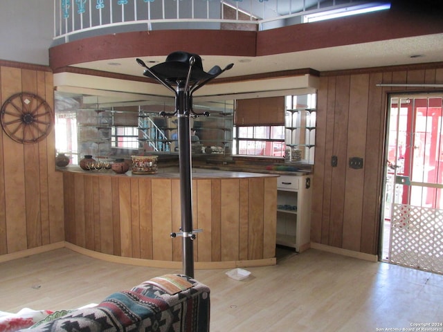 interior space with wooden walls, light hardwood / wood-style flooring, and crown molding