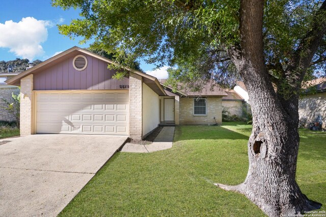 single story home with a garage and a front lawn