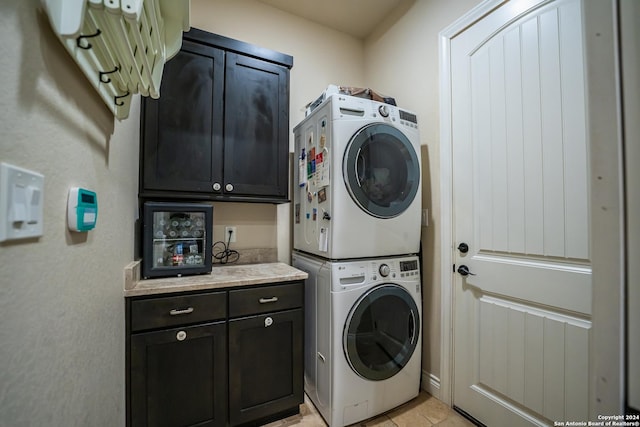 washroom with cabinets and stacked washer / dryer