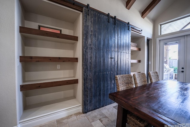 unfurnished dining area featuring vaulted ceiling with beams and a barn door