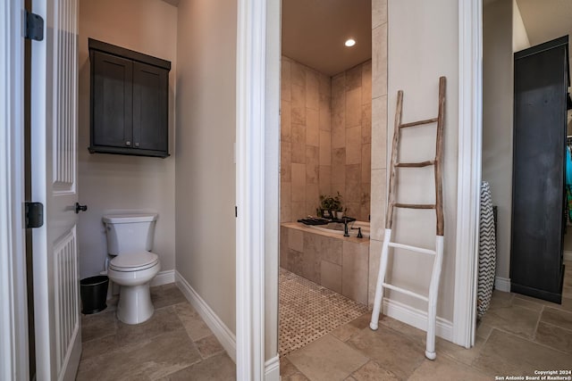 bathroom with toilet and tiled tub