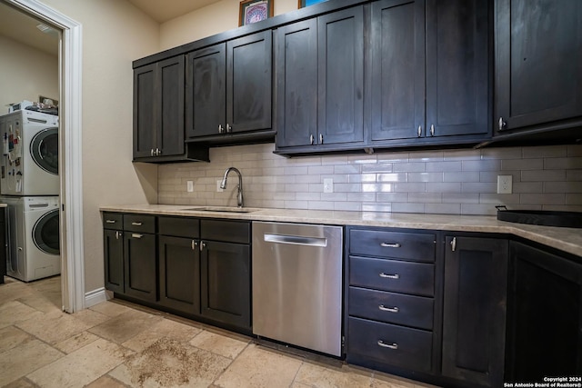 kitchen featuring stainless steel dishwasher, stacked washer / drying machine, decorative backsplash, and sink