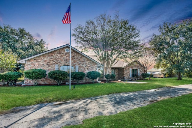 ranch-style home with a yard