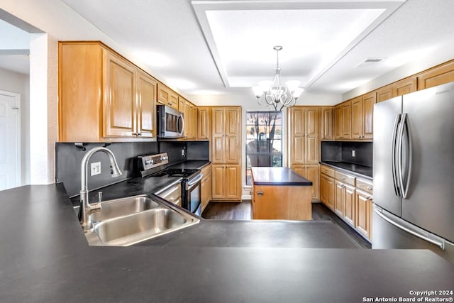 kitchen featuring pendant lighting, a center island, sink, stainless steel appliances, and a chandelier