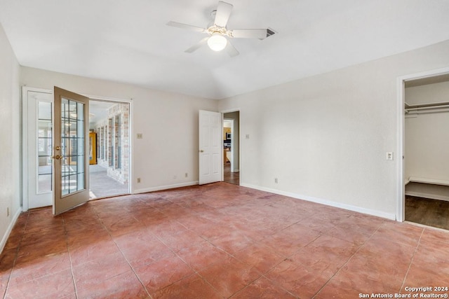 unfurnished bedroom featuring ceiling fan, french doors, access to outside, a walk in closet, and a closet