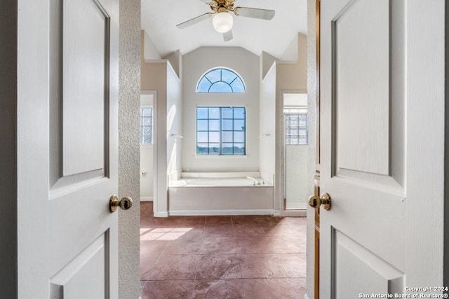 bathroom with tile patterned floors, ceiling fan, a tub, and vaulted ceiling