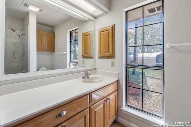 bathroom featuring a tile shower and vanity