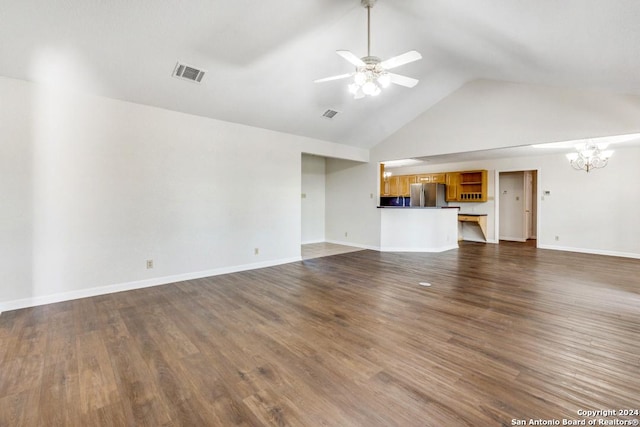 unfurnished living room with high vaulted ceiling, dark wood-type flooring, and ceiling fan with notable chandelier