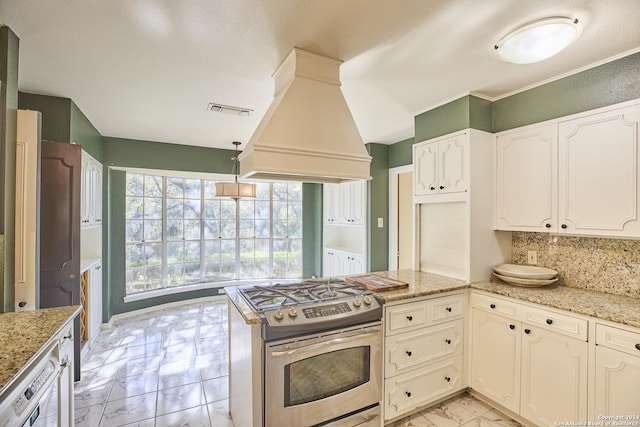 kitchen with light stone countertops, white cabinetry, stainless steel appliances, and custom range hood