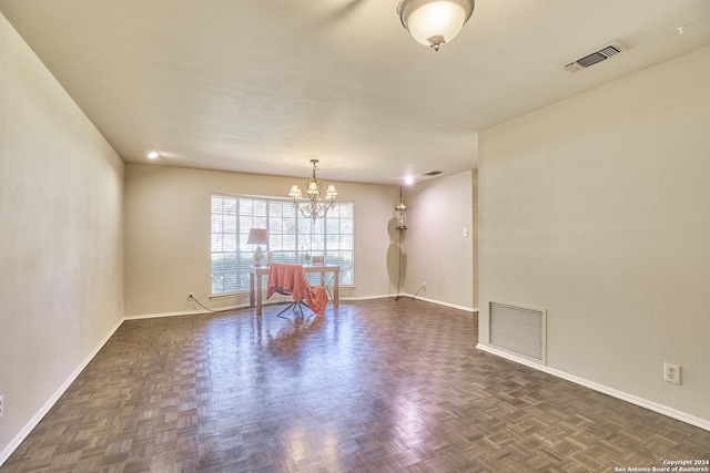 unfurnished room featuring dark parquet floors and a notable chandelier