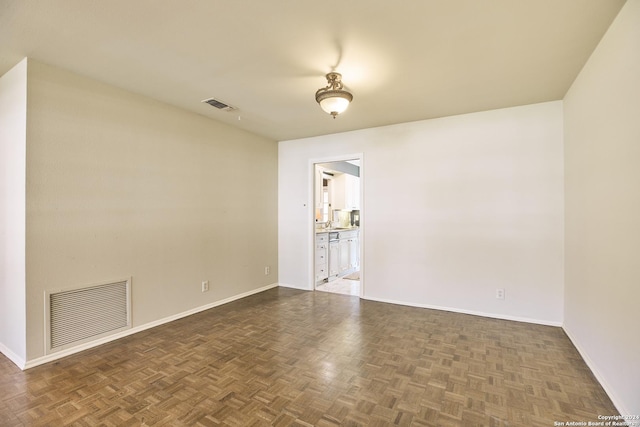 spare room with dark parquet flooring