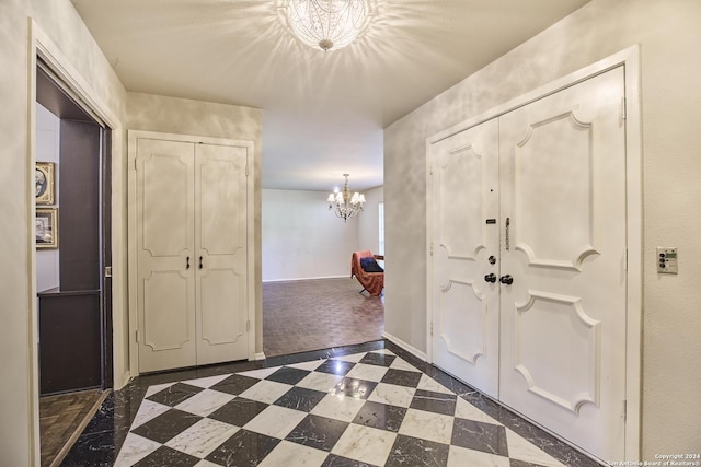 carpeted entrance foyer with a notable chandelier