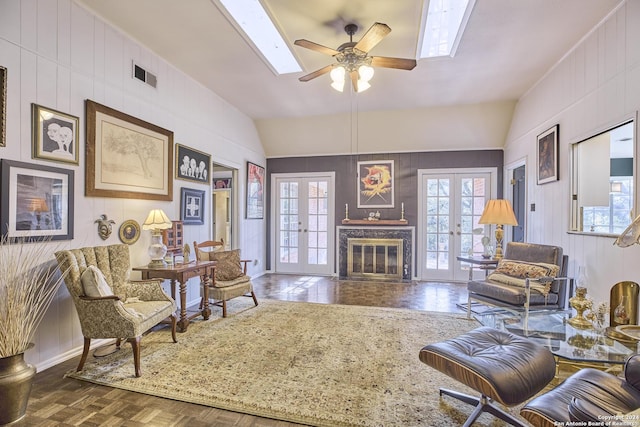 living room with vaulted ceiling, a healthy amount of sunlight, and french doors