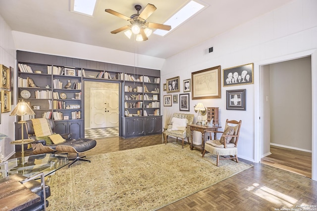 living area with built in shelves, dark parquet flooring, lofted ceiling, and ceiling fan