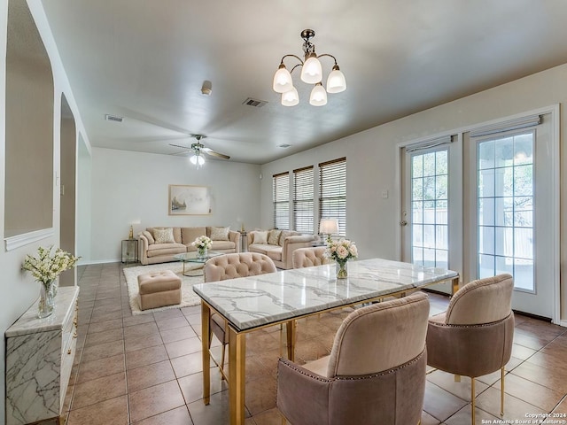 dining area featuring ceiling fan with notable chandelier and light tile patterned floors