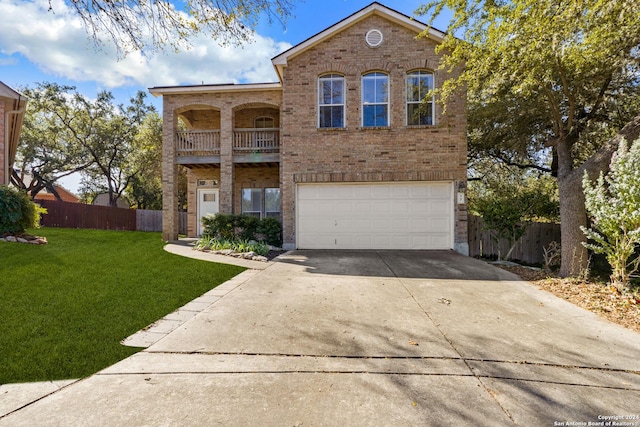 front of property with a garage, a balcony, and a front lawn