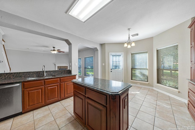 kitchen with dishwasher, sink, pendant lighting, light tile patterned floors, and ceiling fan with notable chandelier