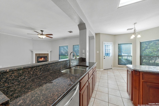 kitchen with plenty of natural light, dark stone countertops, sink, and hanging light fixtures