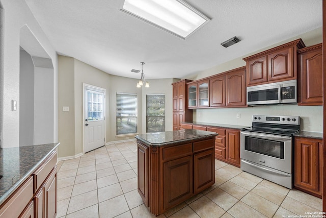 kitchen with decorative light fixtures, light tile patterned flooring, appliances with stainless steel finishes, and a chandelier