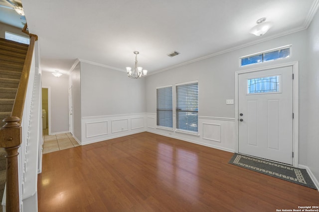 foyer featuring ceiling fan with notable chandelier, light hardwood / wood-style floors, and crown molding