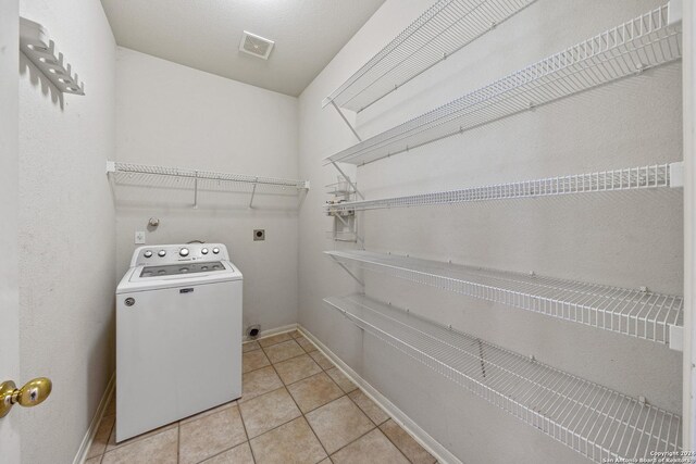 laundry room with washer / dryer and light tile patterned floors