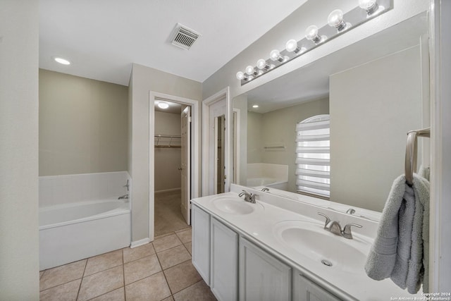 bathroom with tile patterned floors, vanity, and a bath