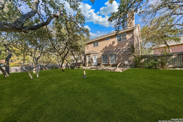 rear view of property featuring a lawn