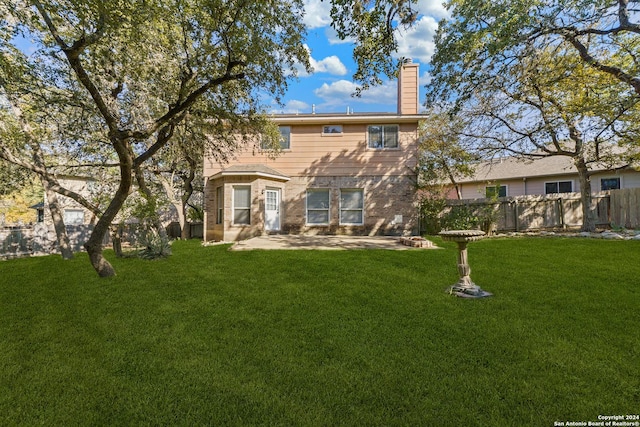 rear view of house with a patio area and a lawn