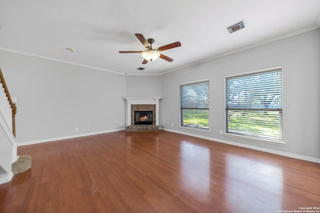 unfurnished living room featuring hardwood / wood-style flooring, ornamental molding, and a fireplace