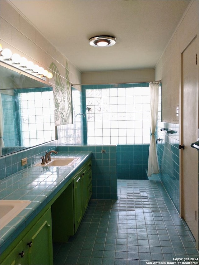 bathroom with tile patterned floors, vanity, and tile walls