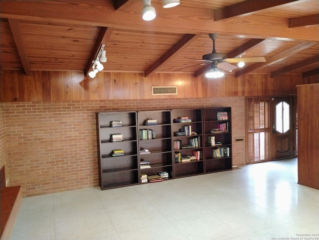 empty room with ceiling fan, wooden walls, and wood ceiling