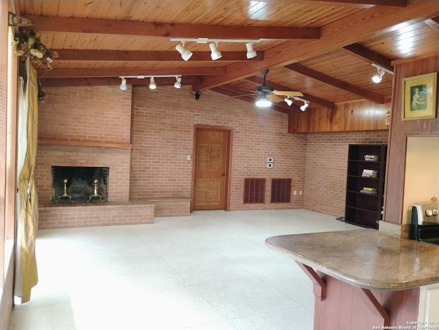 living room with brick wall, ceiling fan, lofted ceiling with beams, wooden ceiling, and a fireplace