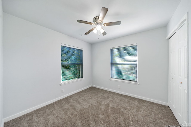 unfurnished bedroom with carpet flooring, ceiling fan, and a closet