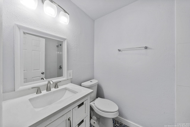 bathroom featuring a shower, vanity, and toilet