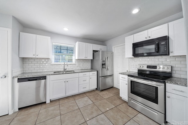 kitchen featuring light stone countertops, sink, light tile patterned floors, white cabinets, and appliances with stainless steel finishes