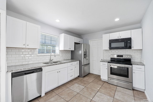 kitchen featuring light stone countertops, white cabinetry, sink, and appliances with stainless steel finishes