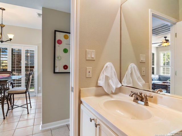 bathroom with tile patterned floors, ceiling fan with notable chandelier, and vanity