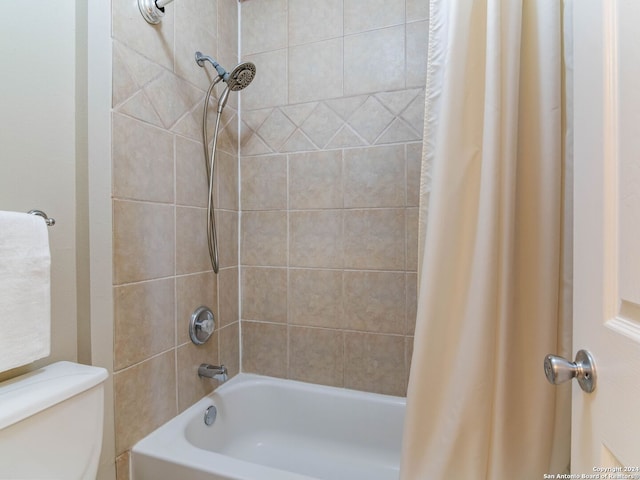 bathroom with shower / tub combo with curtain and toilet