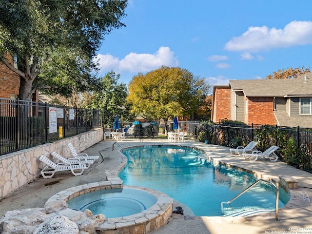 view of swimming pool featuring a patio area and a hot tub