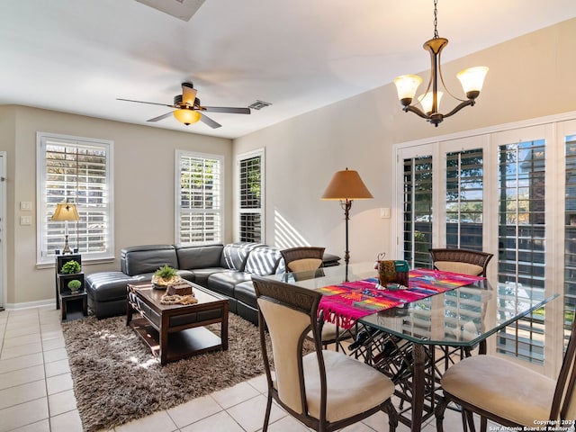 tiled living room with ceiling fan with notable chandelier