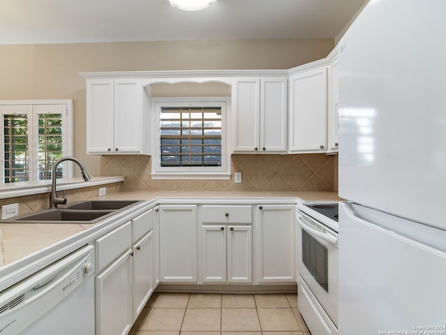 kitchen with white cabinets, decorative backsplash, white appliances, and sink