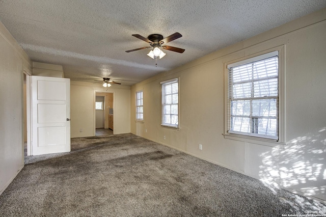 carpeted spare room with ceiling fan and a textured ceiling