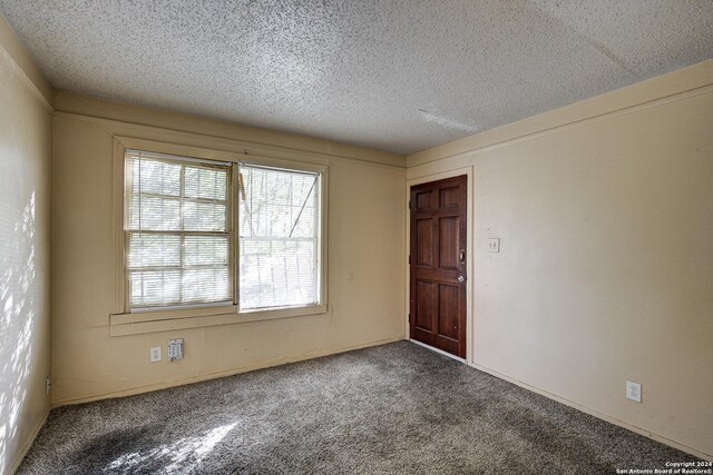 carpeted spare room with a textured ceiling