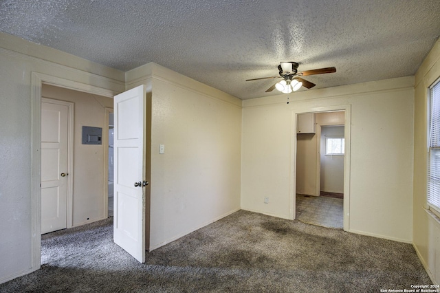 carpeted empty room with ceiling fan and a textured ceiling