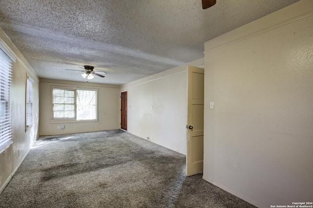 carpeted empty room featuring ceiling fan and a textured ceiling