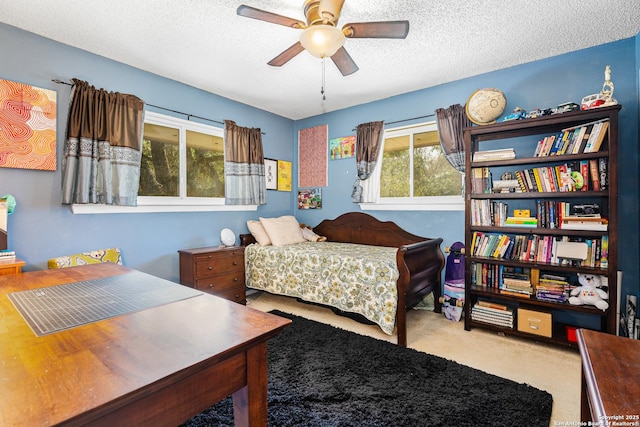 carpeted bedroom with a textured ceiling and a ceiling fan